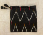 Cotton black pouch has a woven decorative zig-zag pattern, drawstring closure