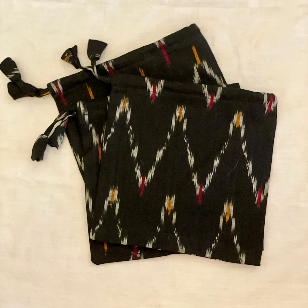 Cotton black pouch has a woven decorative zig-zag pattern, drawstring closure