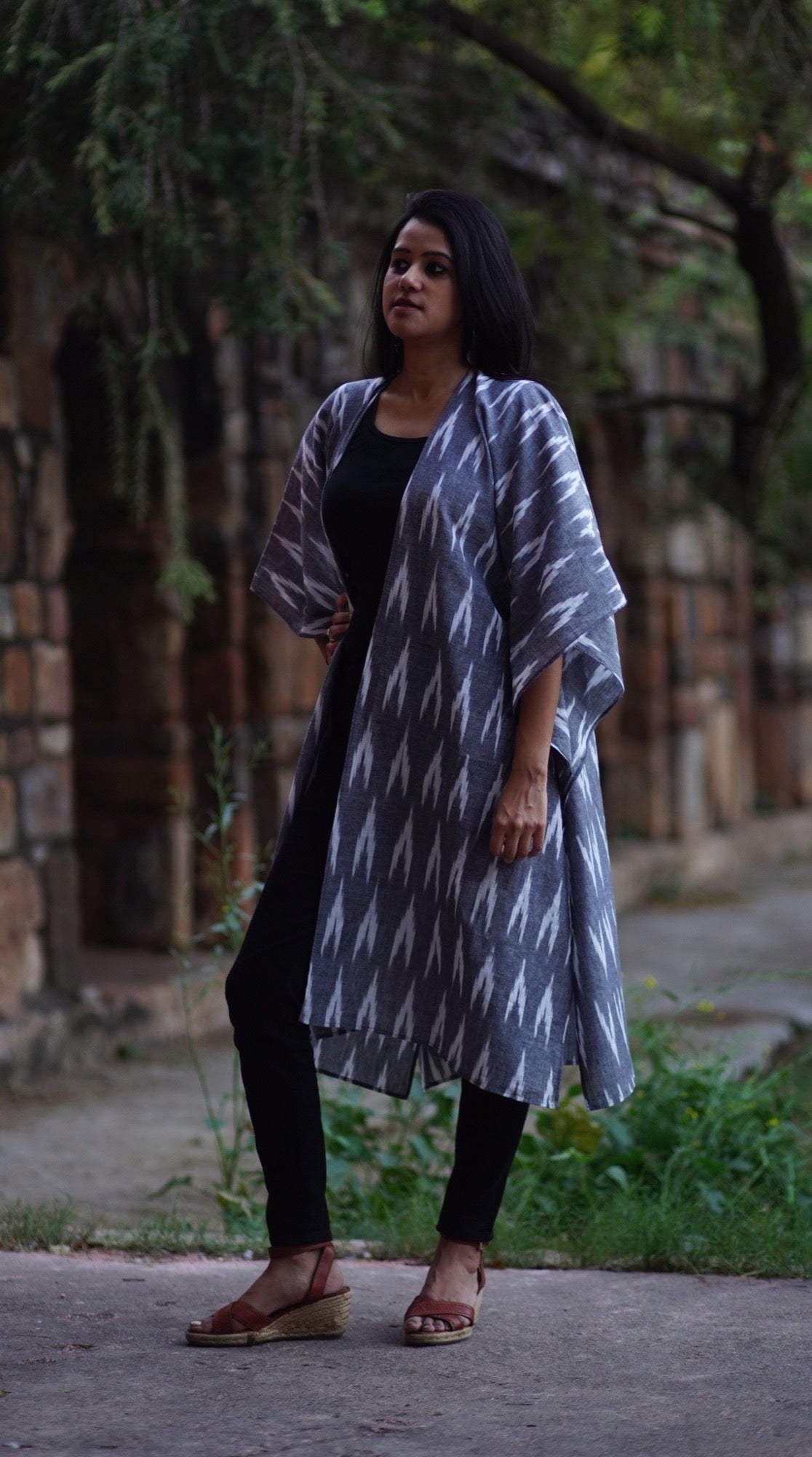woman wearing a grey ikat kimono shrug sustainably sewn by sewing new futures NGO  